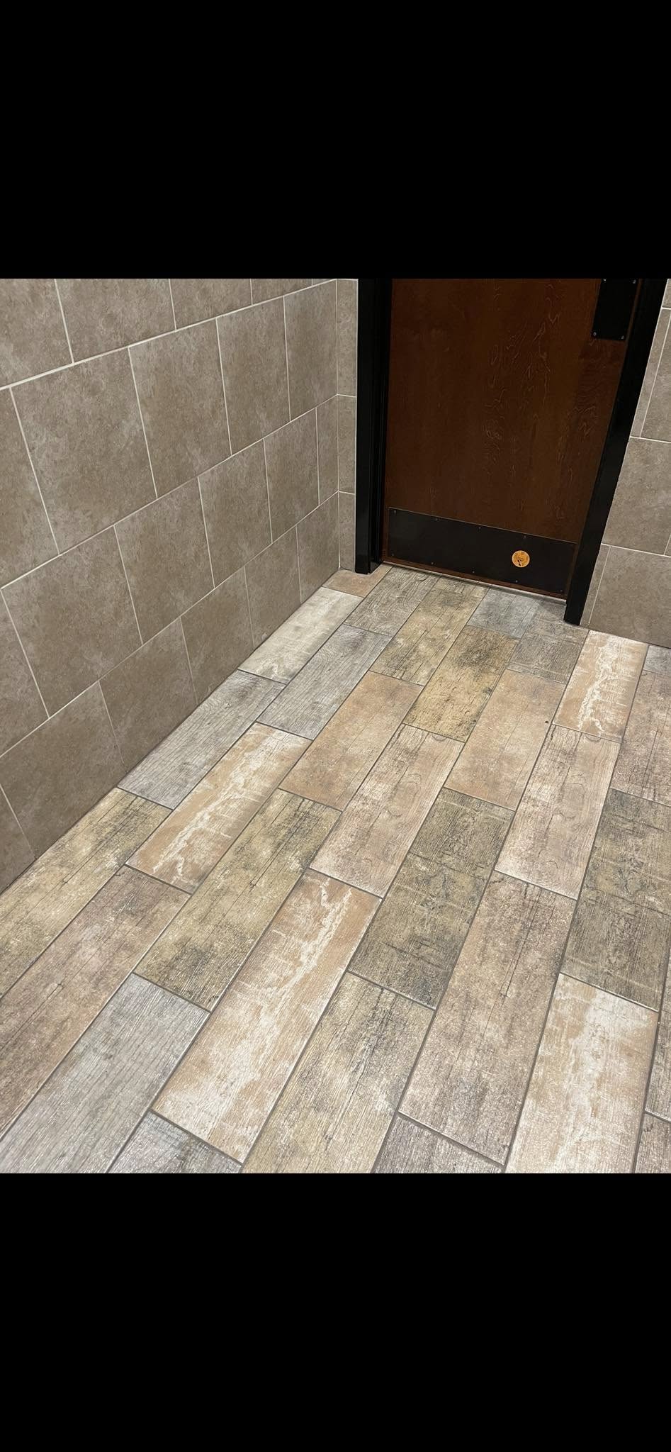 JNL Flooring bathroom tile floor meeting the tiled wall and doorway